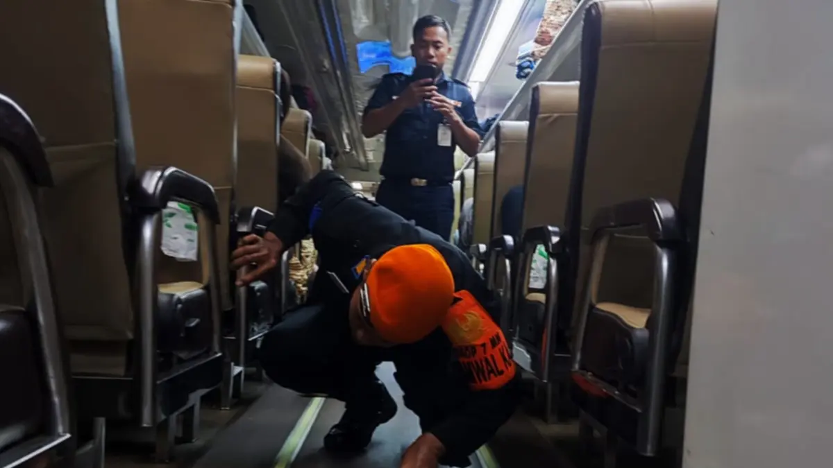 Petugas mengamankan ular yang ditemukan di bawah kursi penumpang KA Kertanegara sebelum diturunkan di Stasiun Madiun. FOTO: HUMAS KAI DAOP 7 MADIUN