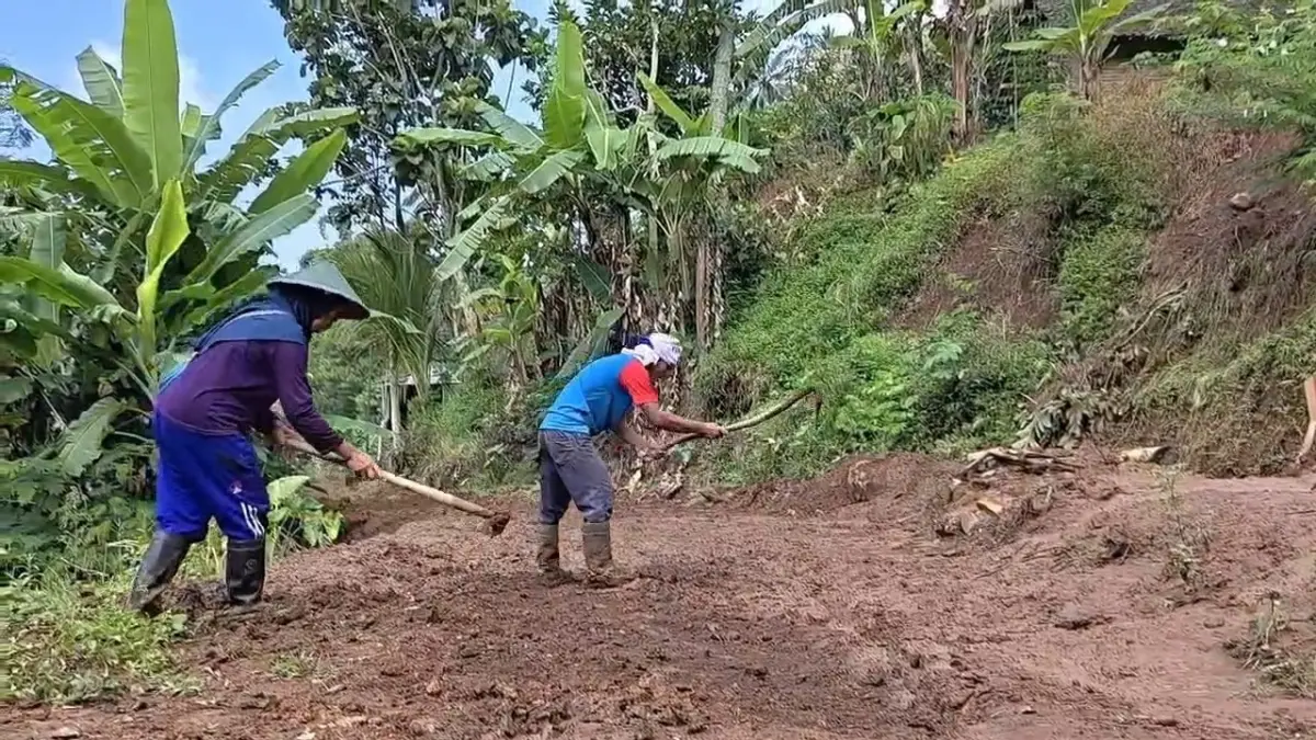 Petugas dan warga membersihkan material longsor yang menutup akses Dusun Gondangsari, Desa Banaran. SUGENG DWI N/RADAR PONOROGO