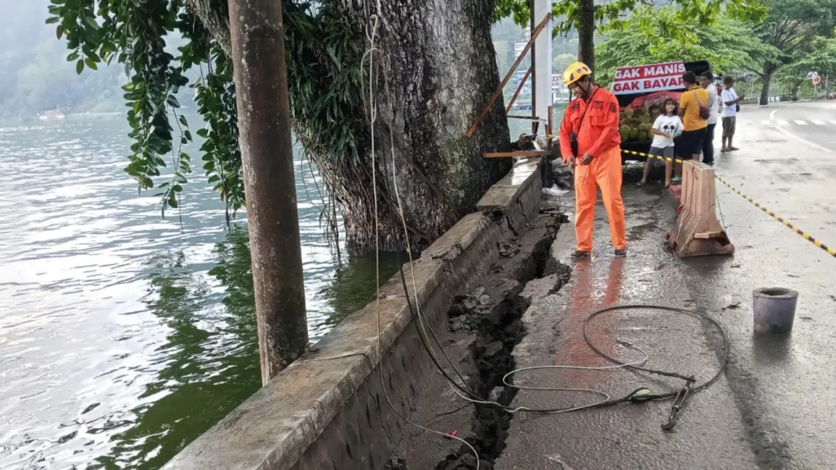Petugas memasang pembatas di area talud Telaga Ngebel yang retak sepanjang 15 meter. FOTO: ISTIMEWA
