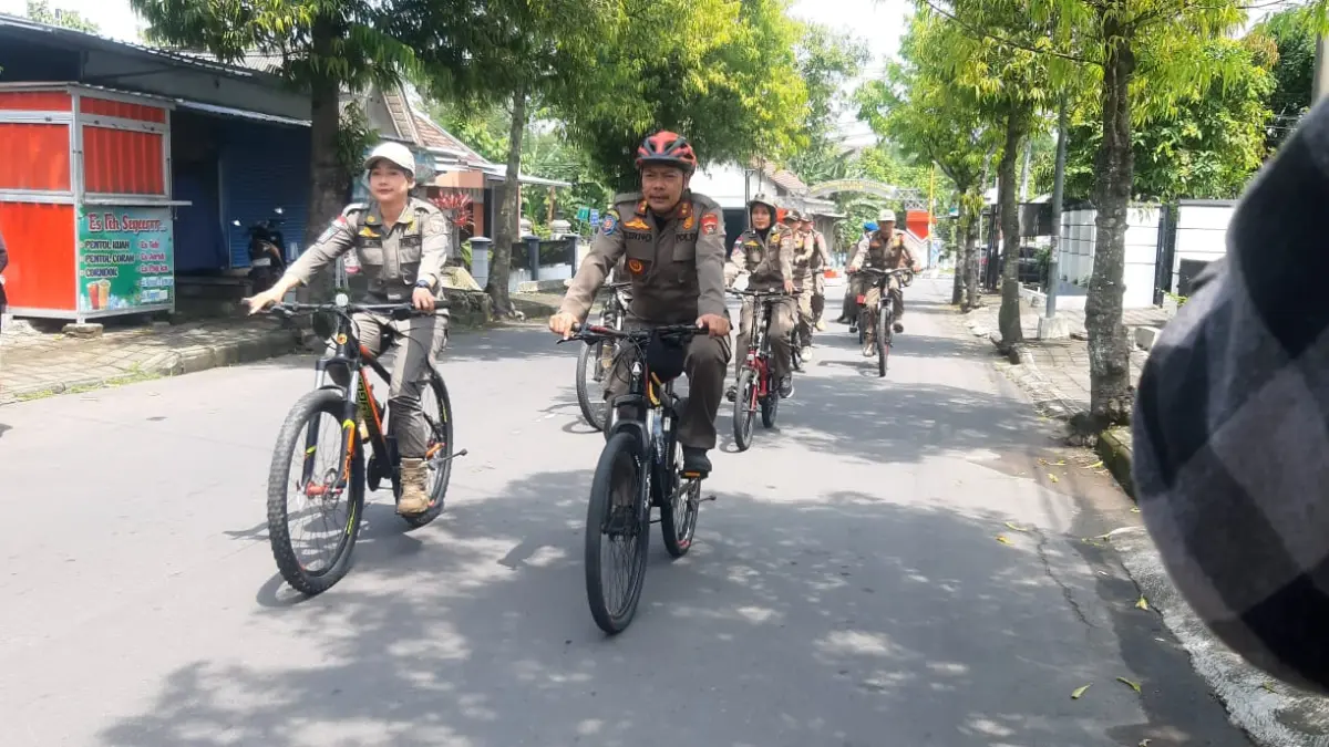 IRIT BBM: Petugas Satpol PP Ngawi berpatroli menggunakan sepeda sambil menertibkan banner liar di sejumlah ruas jalan kota, kemarin (6/4). ASEP SYAEFUL BACHRI/JAWA POS RADAR NGAWI