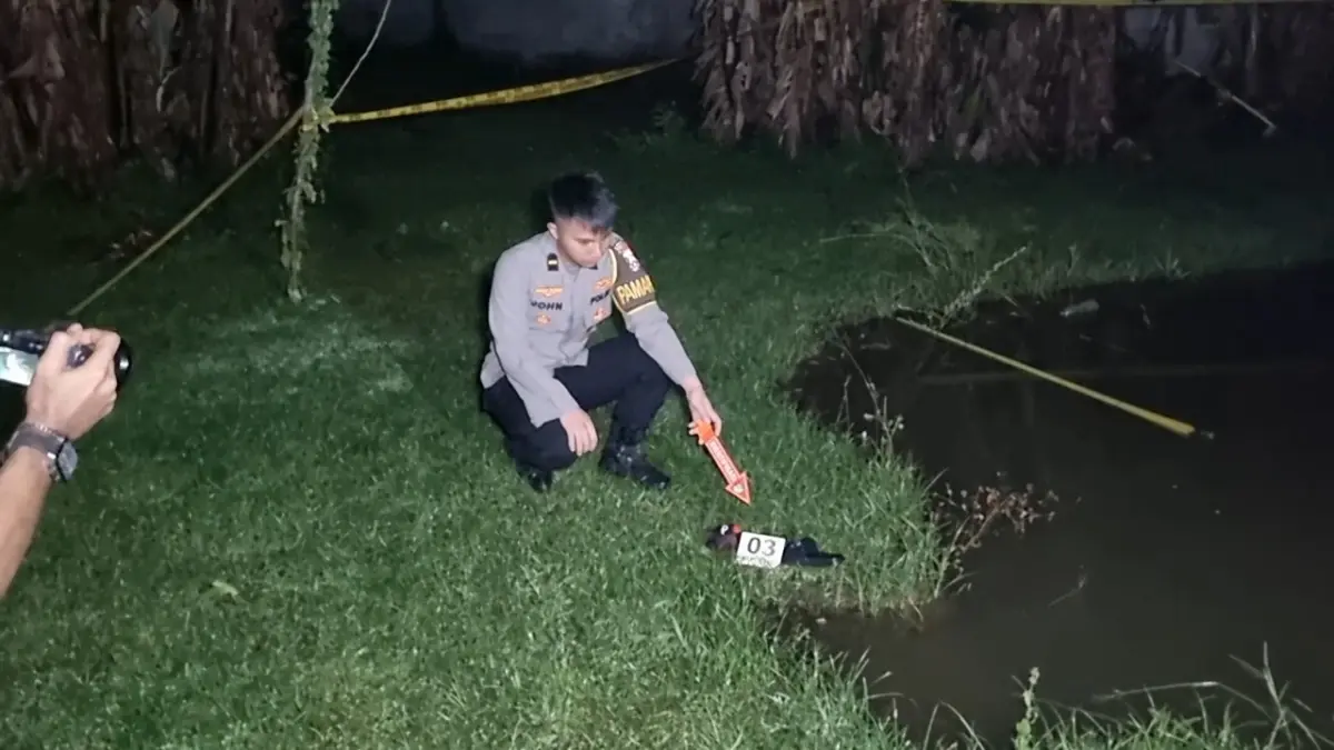 Petugas memasang garis polisi di lokasi kubangan air Desa Madusari, Siman, Ponorogo, tempat dua bocah ditemukan tenggelam. FOTO: SUGENG DWI N/RADAR PONOROGO