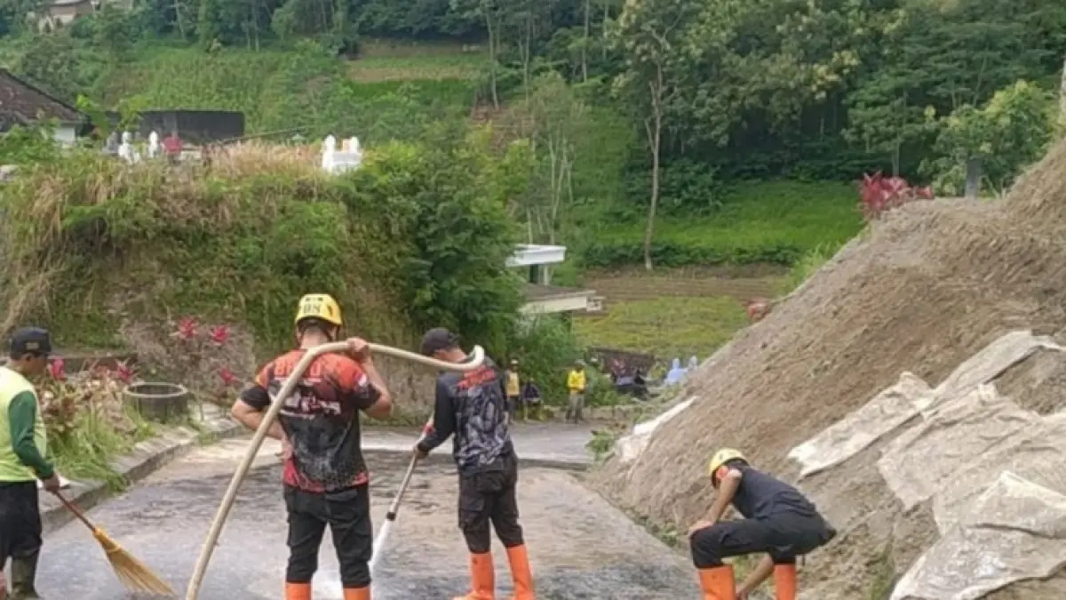 Petugas bersama warga mengevakuasi material longsor yang menutup akses jalan antar-RT di Poncol, Magetan. FOTO: BPBD MAGETAN