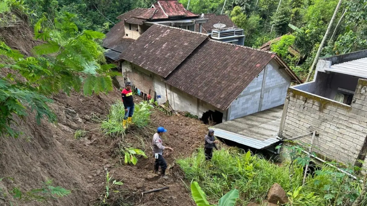Petugas dan warga membersihkan material longsor yang menutup akses jalan di Kecamatan Nawangan, Pacitan. FOTO: ISTIMEWA