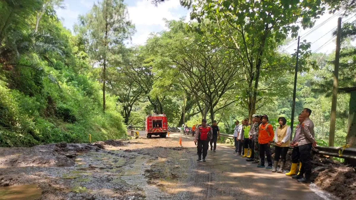 Petugas membersihkan material longsor yang menutup jalur Ponorogo–Pacitan di wilayah Slahung. FOTO: SUGENG DWI N/RADAR PONOROGO