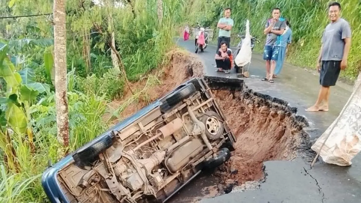 Suzuki Carry terperosok akibat bahu jalan ambles di jalur Bandar–Jeruk, Pacitan usai hujan deras. FOTO: ISTIMEWA