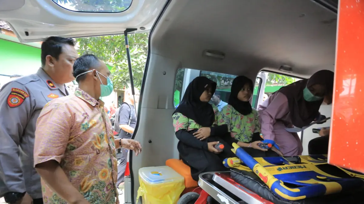 Petugas menangani siswa yang mengalami gejala diduga keracunan makanan MBG di Kota Madiun. BAGAS BIMANTARA/RADAR MADIUN