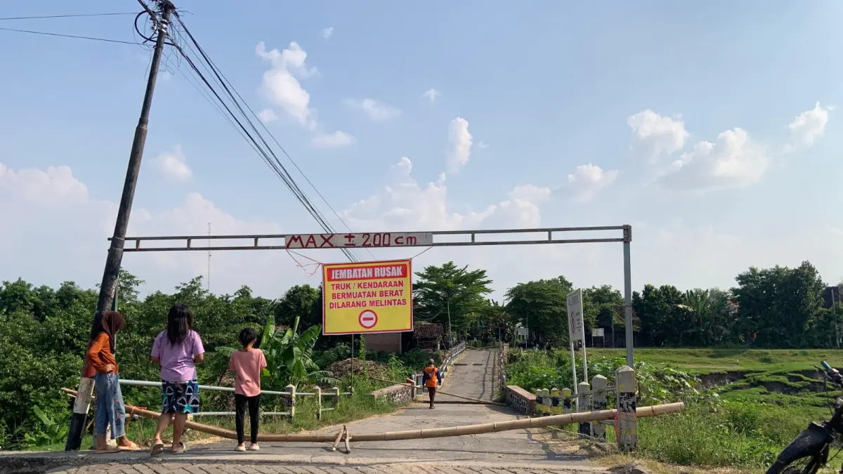Kondisi Jembatan Plumpung di Desa Glonggong ambles hingga satu meter dan ditutup total untuk keselamatan warga. LODITYA FERNANDES/RADAR MADIUN