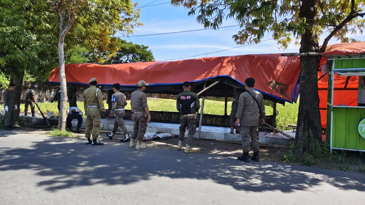 Petugas Satpol PP dan Damkar Ponorogo menertibkan rombong PKL yang ditinggal di bahu jalan. DOK RADAR PONOROGO