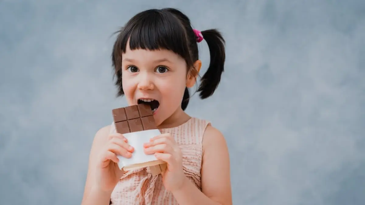 Ilustrasi anak makan cokelat dan dampaknya untuk kesehatan gigi.