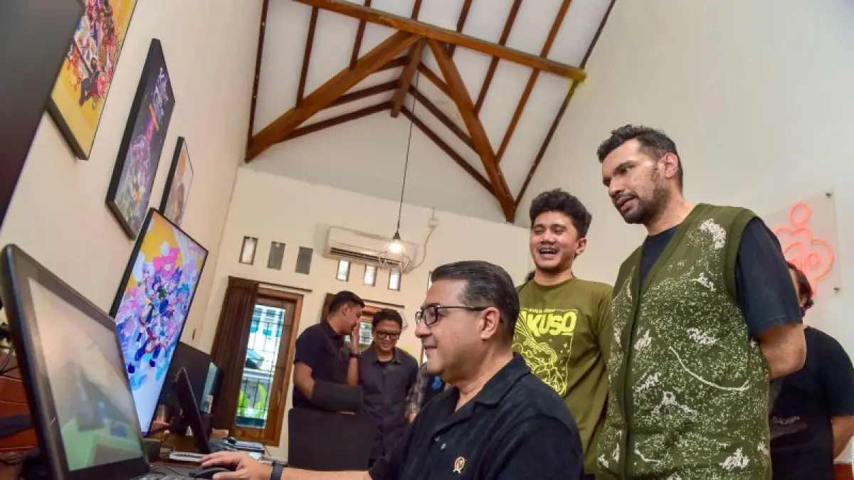 Menteri Ekonomi Kreatif Teuku Riefky Harsya mencoba produk gim lokal saat mengunjungi Gambir Studio di Yogyakarta, Sabtu (25/4). (ANTARA)
