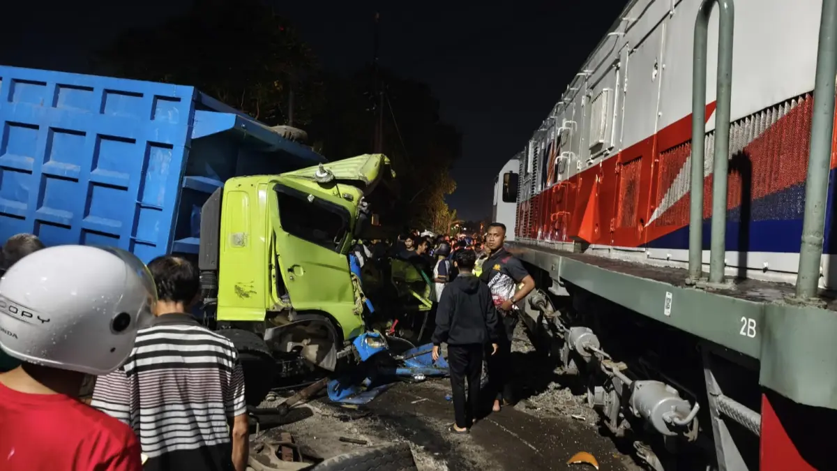 Petugas mengevakuasi truk yang tertemper KA Dhoho di perlintasan sebidang Blitar setelah mogok di tengah rel. FOTO: KAI DAOP 7 MADIUN