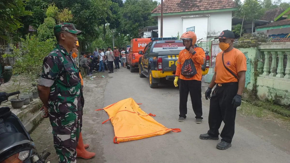 Petugas mengevakuasi jenazah yang ditemukan di aliran sungai wilayah Desa Sidorejo, Wungu. LODITYA FERNANDES/RADAR MADIUN