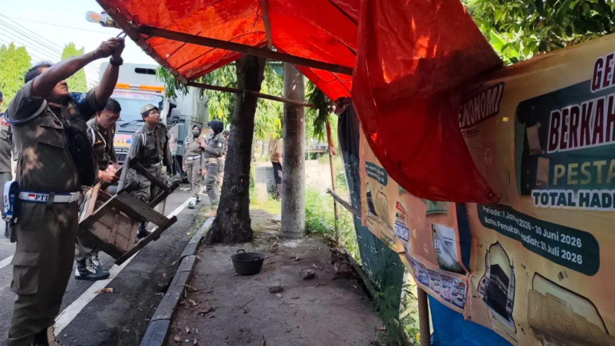Petugas Satpol PP dan Damkar Ponorogo membongkar lapak PKL yang ditinggal di kawasan Jalan Juanda. SUGENG DWI N/RADAR PONOROGO