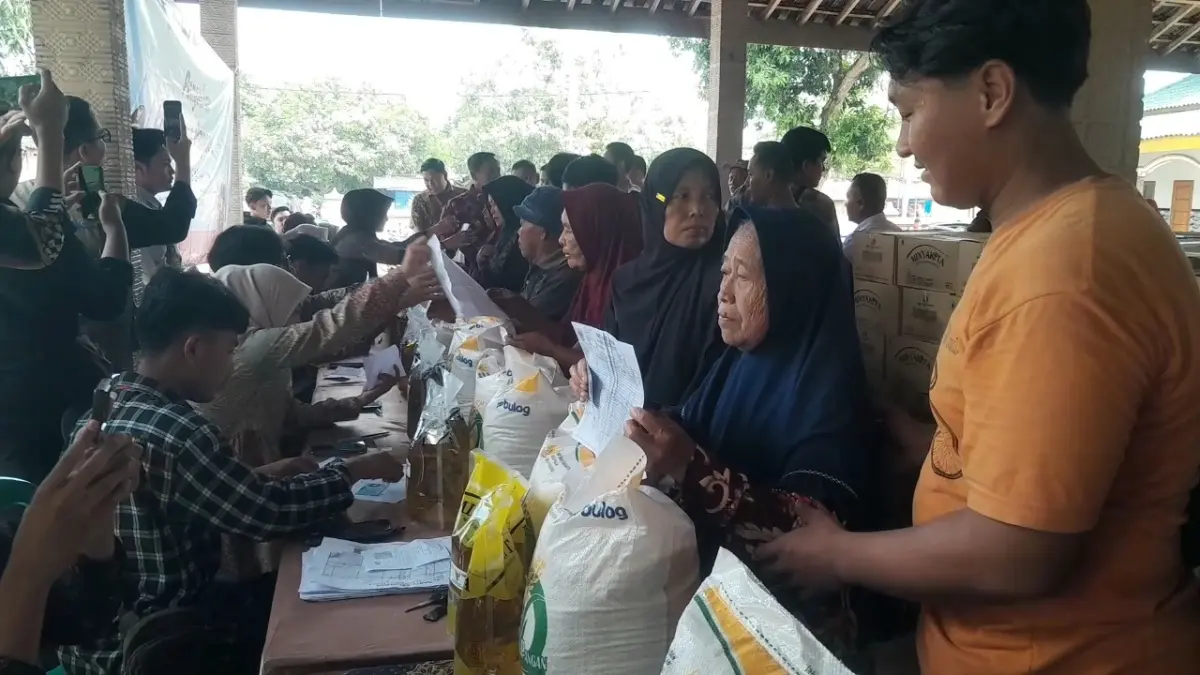 PENYALURAN BANTUAN: Warga mengambil bantuan pangan berupa beras dan minyak goreng di Desa Watualang, Ngawi, Kamis (30/4). Sebanyak 166 ribu KPM menerima bantuan. ASEP SYAEFUL/RADAR NGAWI