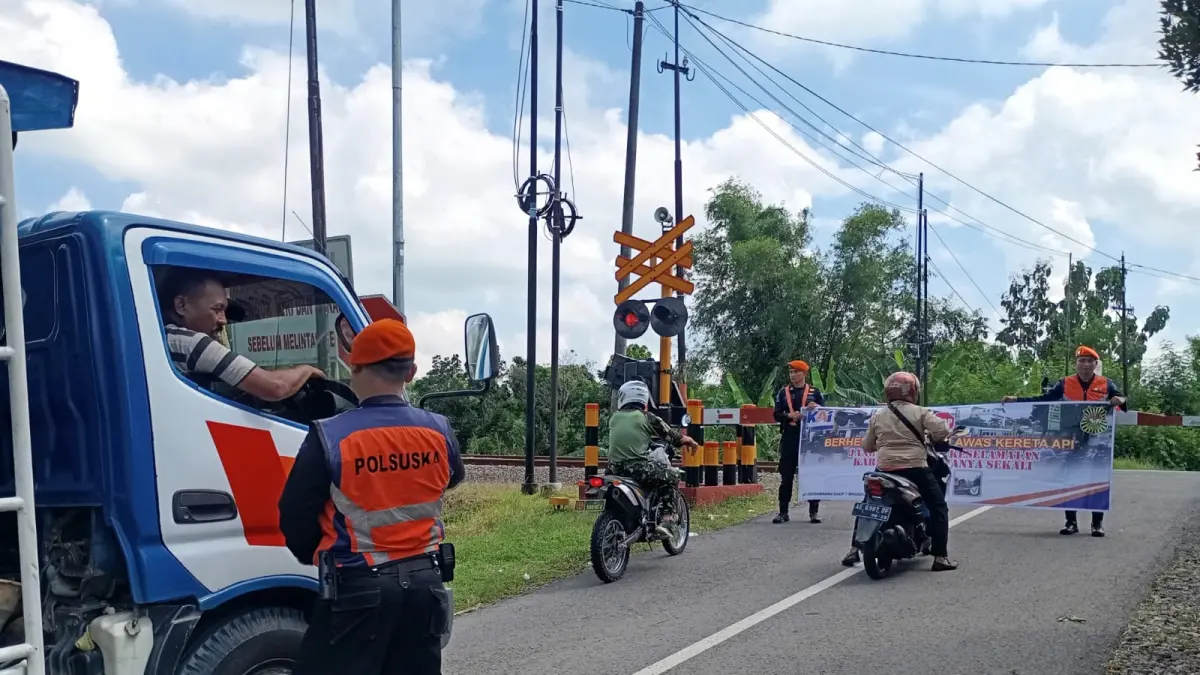 Petugas berjaga di perlintasan sebidang wilayah Daop 7 Madiun, lokasi rawan kecelakaan akibat pelanggaran pengguna jalan. FOTO: KAI DAOP 7 MADIUN