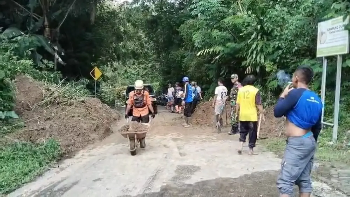 Petugas gabungan bersama warga membersihkan material longsor di jalur Madiun–Ngebel, Dukuh Sekodok, hingga akses kembali normal. FOTO: POLSEK NGEBEL