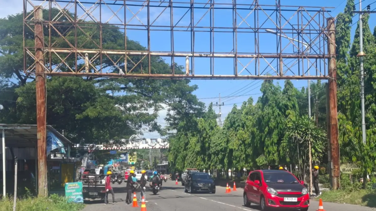 Petugas gabungan membongkar papan reklame usang di Jalan Ponorogo–Madiun yang membahayakan pengguna jalan. SUGENG DWI N/RADAR PONOROGI