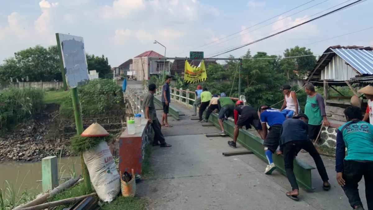 Pekerja DPUPR menyiapkan pemasangan baja WF sebagai penanganan darurat Jembatan Plumpung yang ambles. LODITYA FERNANDES/RADAR MADIUN