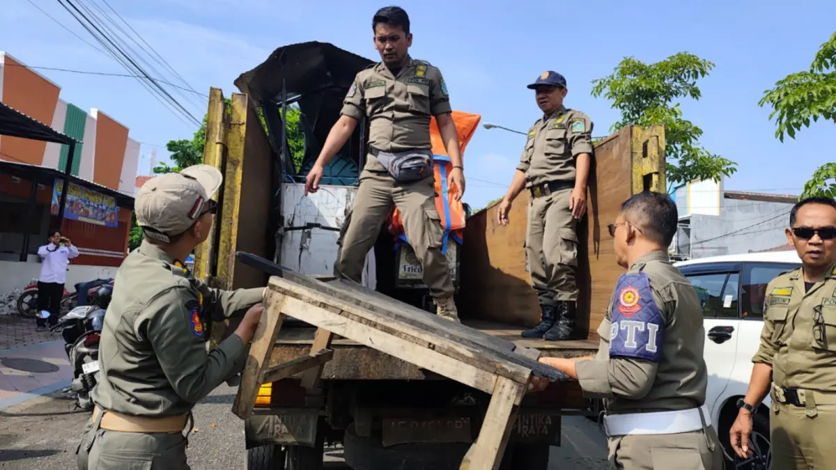 Petugas gabungan membongkar lapak PKL yang ditinggal di tepi Jalan Juanda dalam operasi penertiban. SUGENG DWI N/RADAR PONOROGO