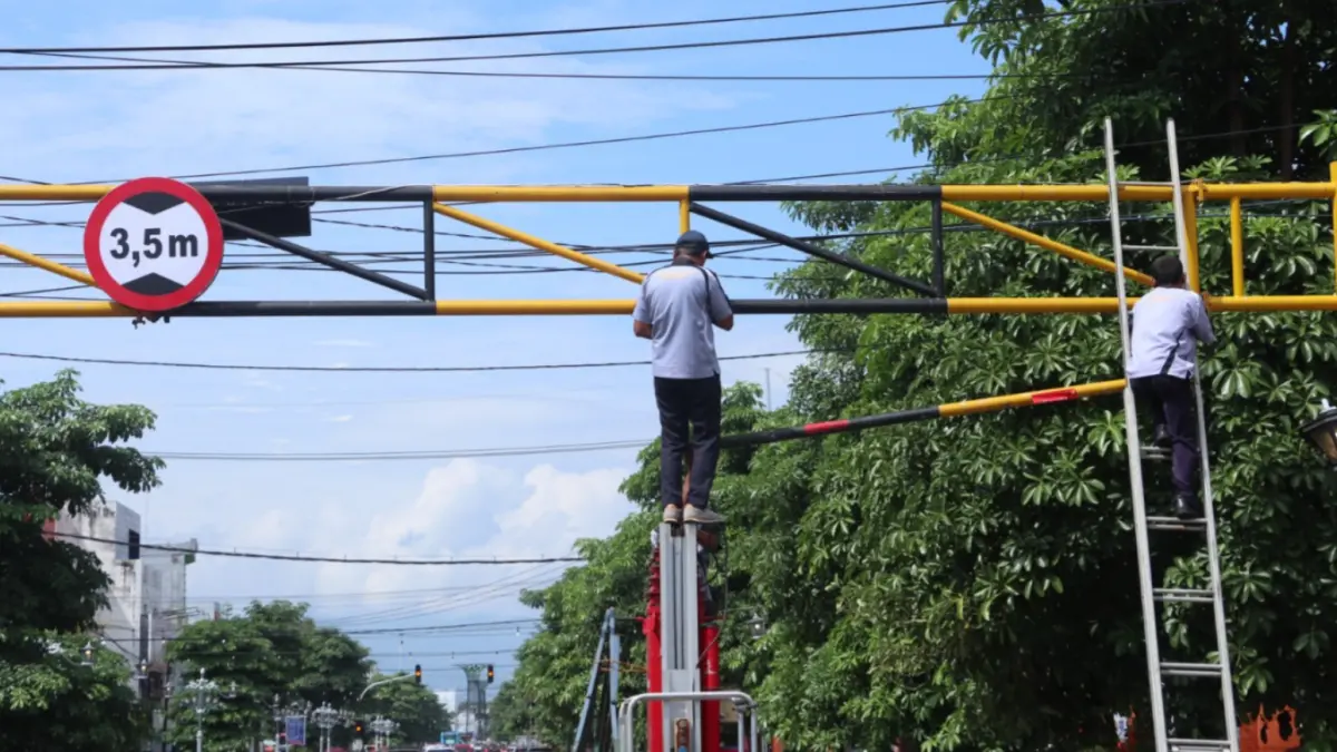 Petugas Dishub Ponorogo memperbaiki portal pembatas ketinggian di Jalan HOS Cokroaminoto yang kembali rusak ditabrak kendaraan. SUGENG DWI N/JAWA POS RADAR PONOROGO