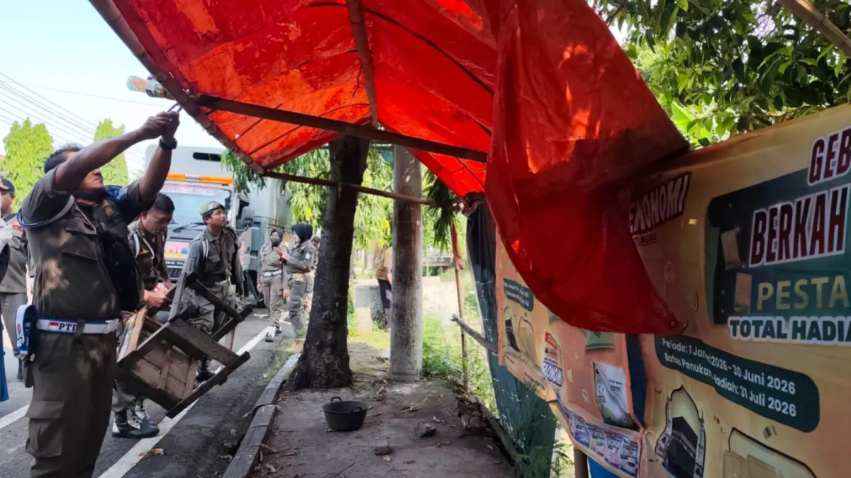 OPERASI PENERTIBAN: Petugas Satpol PP Damkar dan Perdagkum Ponorogo melakukan pengawasan terhadap PKL yang masih menggunakan trotoar sebagai lapak permanen. DOK JAWA POS RADAR PONOROGO