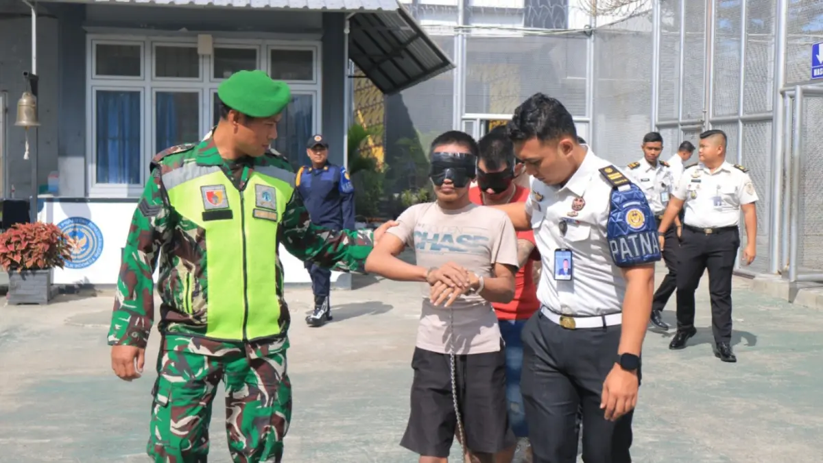 Petugas mengawal proses pemindahan puluhan warga binaan Lapas Pemuda Madiun ke sejumlah lembaga pemasyarakatan di Jawa Timur. FOTO: LAPAS PEMUDA MADIUN