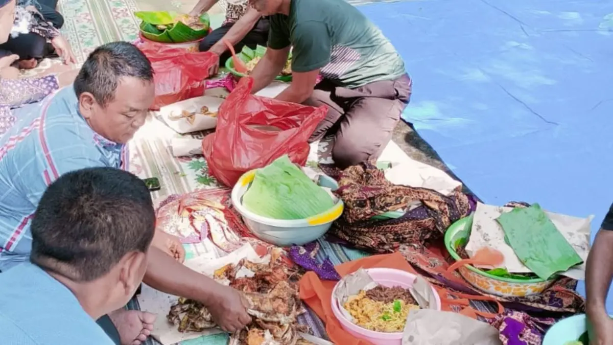 BERBAGI: Warga membagikan makanan usai doa bersama di lokasi Nyadran.