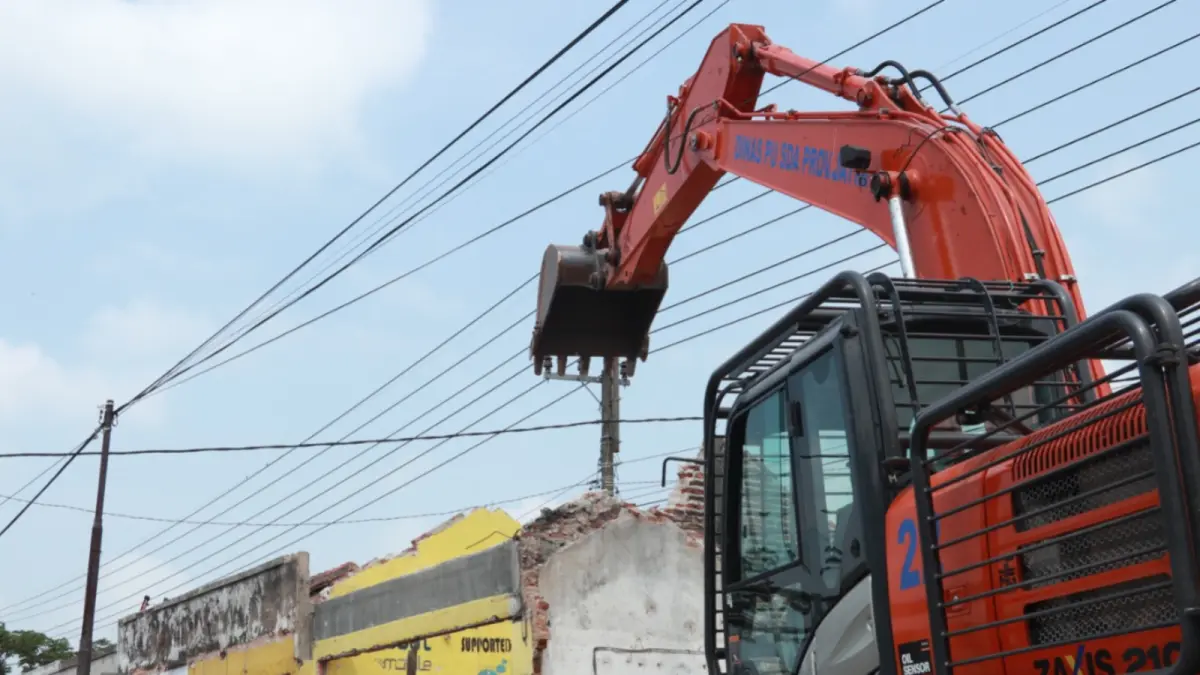Petugas DPU SDA Jawa Timur menggunakan alat berat untuk membongkar ruko ilegal yang berdiri di atas saluran irigasi di Desa Dengok, Kecamatan Siman, Rabu (20/5). SUGENG DWI N/JAWA POS RADAR PONOROGO