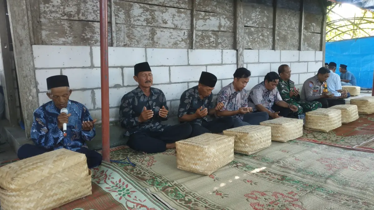 DOA DAN SEDEKAH BUMI: Selain pagelaran, juga dilakukan kenduri dengan doa memohon keselamatan, dilanjutkan dengan pembagian makanan yang sudah dikemas dalam wadah besek. (SATRIO JATI/ RADAR MADIUN)