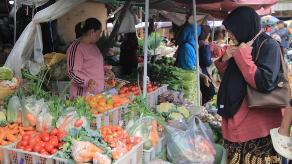 Pedagang sayuran di Pasar Agrobis Plaosan Magetan melayani pembeli di tengah kenaikan harga cabai dan sayuran menjelang Idul Adha. AJI PUTRA/JAWA POS RADAR MAGETAN