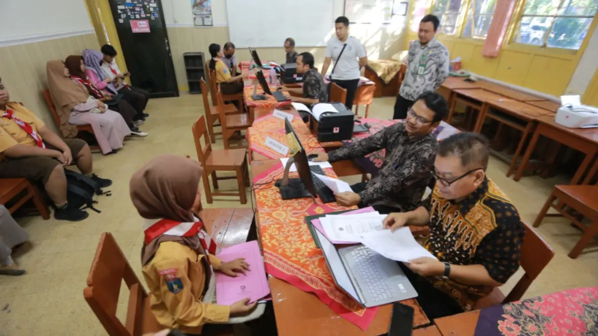 Petugas melakukan verifikasi data calon peserta didik pada tahapan pengambilan PIN SPMB 2026 di SMAN 1 Madiun. BAGAS BIMANTARA/JAWA POS RADAR MADIUN