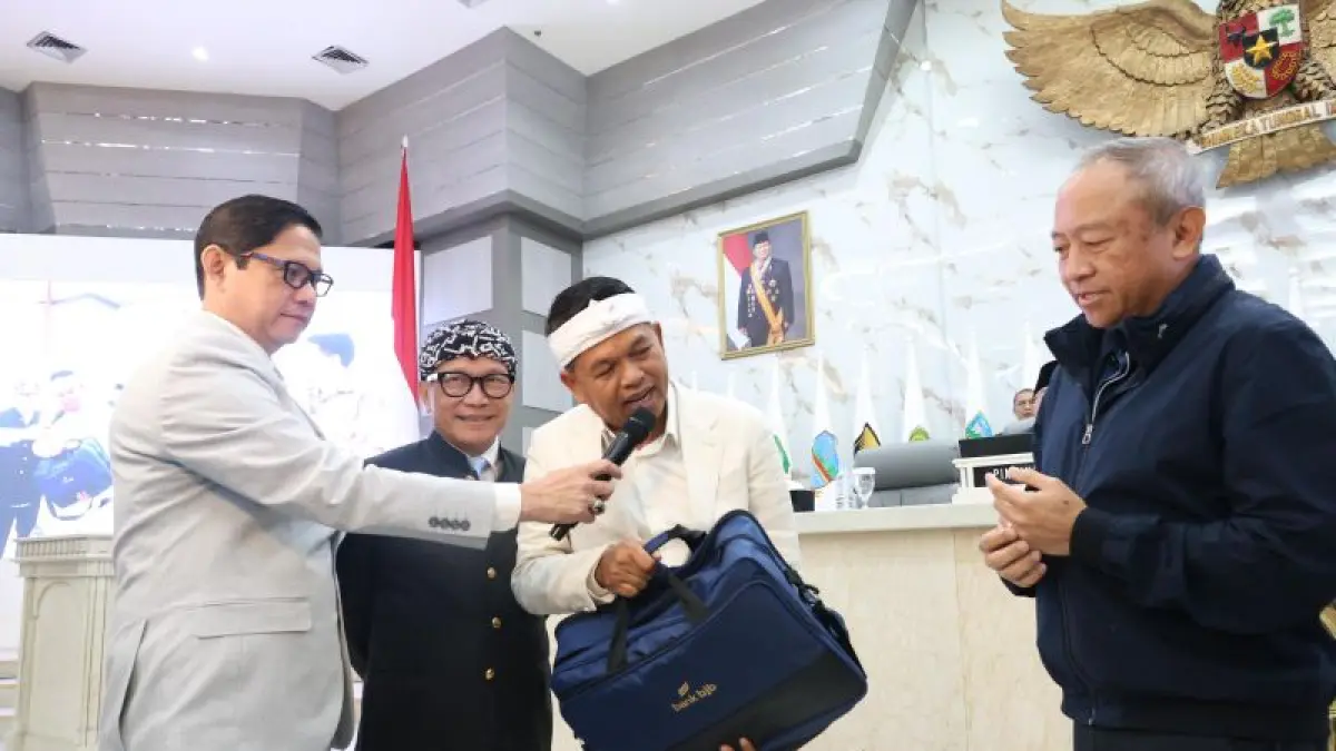 Gubernur Jabar Dedi Mulyadi memberikan sekoper bonus untuk Persib melalui Direktur Utama PT Persib Bandung Bermartabat Glenn Sugita di Bandung, Rabu (3/6). (ANTARA)
