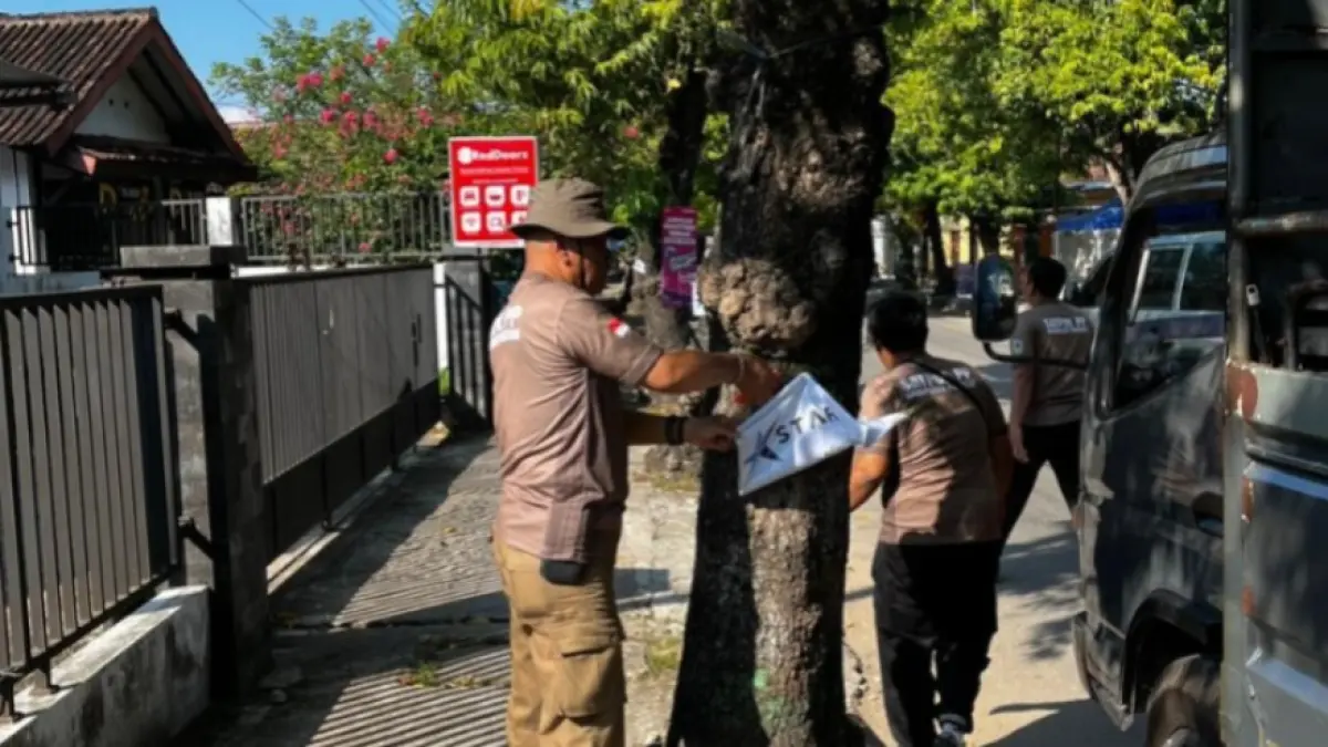 BONGKAR REKLAME: Petugas Satpol PP Pacitan menurunkan banner dan spanduk yang melanggar aturan di sejumlah ruas jalan, kemarin (7/6). NUR CAHYONO/JAWA POS RADAR PACITAN