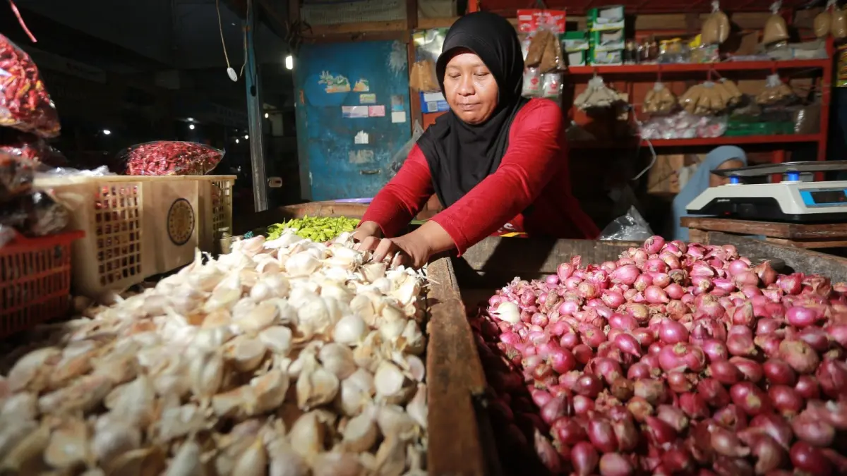 HARGA MEROKET: Pedagang di Pasar Besar Madiun melayani pembeli bawang putih. BAGAS BIMANTARA/RADAR MADIUN