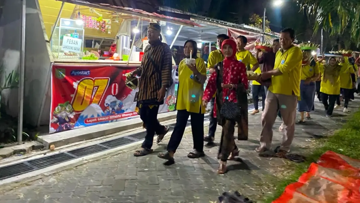 BUDAYA LELUHUR: Pedagang dan pelaku UMKM Paguyuban Sedayu Winongo mengikuti kirab lima tumpeng dalam tradisi Mapak Suro, Kamis malam (11/6). ERLITA HERMININGSIH/RADAR MADIUN