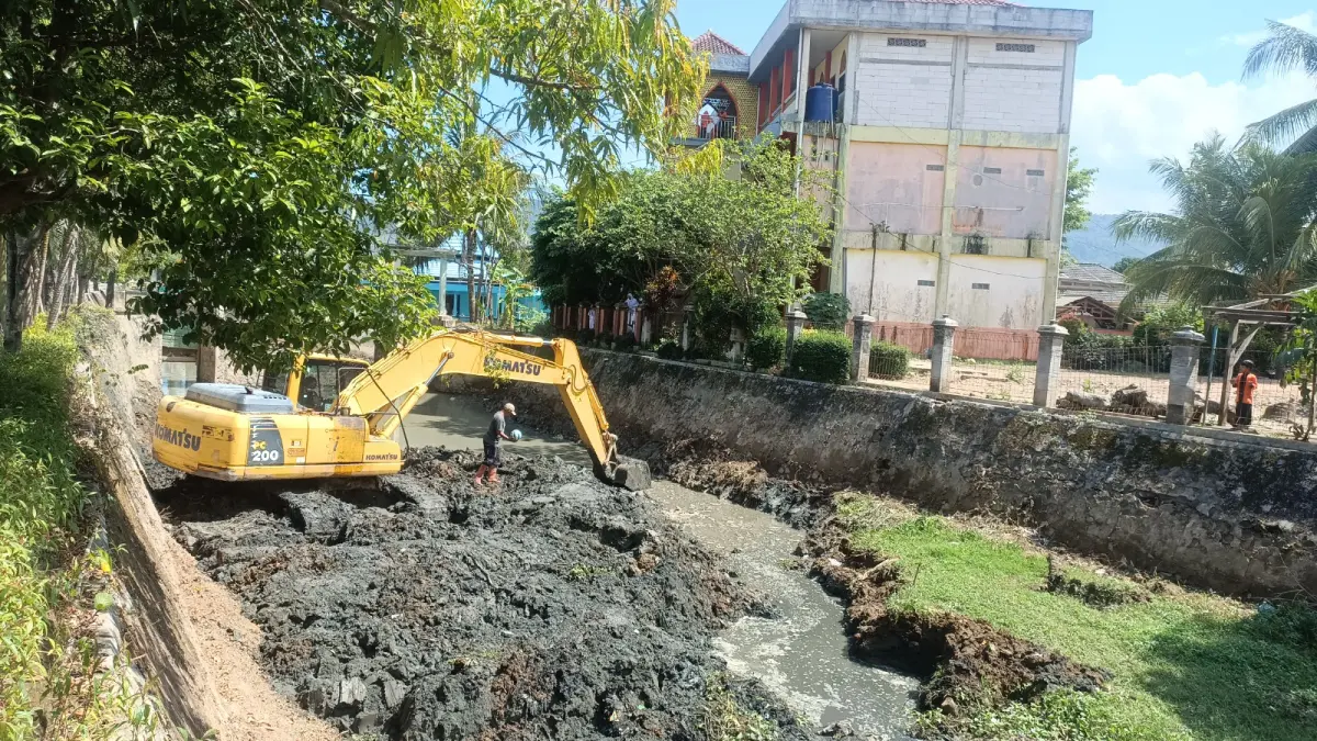 NORMALISASI SALURAN: Endapan lumpur di salah satu saluran drainase kawasan Kota Pacitan dikeruk menggunakan alat berat. NUR CAHYONO/RADAR PACITAN