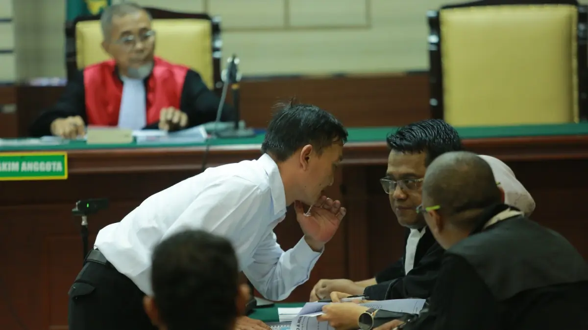 SIAPKAN EKSEPSI: Terdakwa Thariq Megah berdiskusi dengan kuasa hukumnya, Mursid Mudiantoro, usai persidangan di Pengadilan Tipikor Surabaya. BAGAS BIMANTARA/RADAR MADIUN