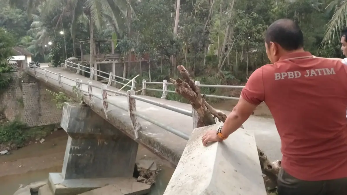 JALUR VITAL: Petugas meninjau kondisi Jembatan Kaligoro di Desa Sumberejo, Kecamatan Sudimoro, yang rusak akibat banjir Februari lalu. FOTO: BPBD PACITAN