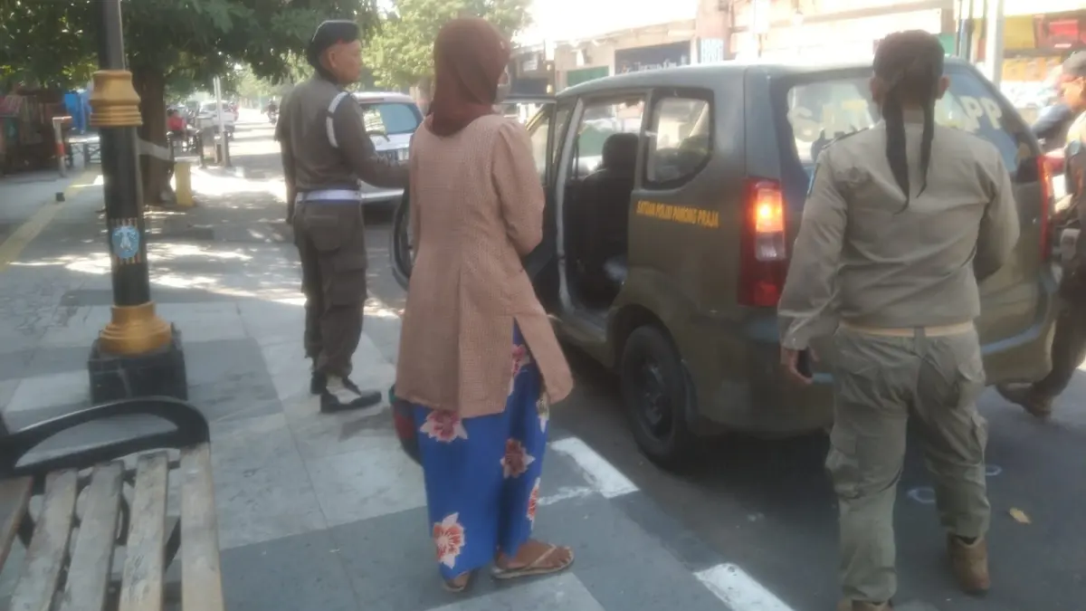 PATROLI KETAT: Petugas Satpol PP dan Damkar Ponorogo mengamankan seorang pengemis saat razia di kawasan simpang Tambakbayan. FOTO: ISTIMEWA