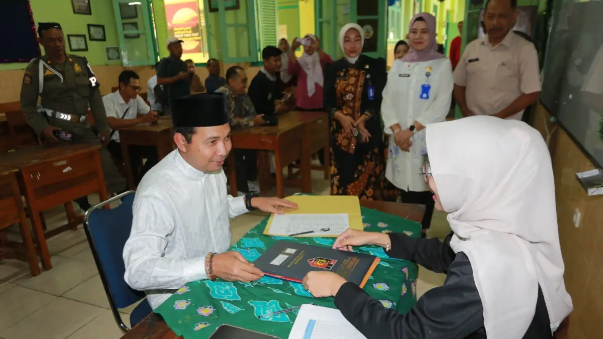 Plt Wali Kota Madiun F. Bagus Panuntun mengambil rapor putrinya, Nayla Caliana Panuntun, di SMPN 1 Madiun, Jumat (19/6). BAGAS BIMANTARA/RADAR MADIUN