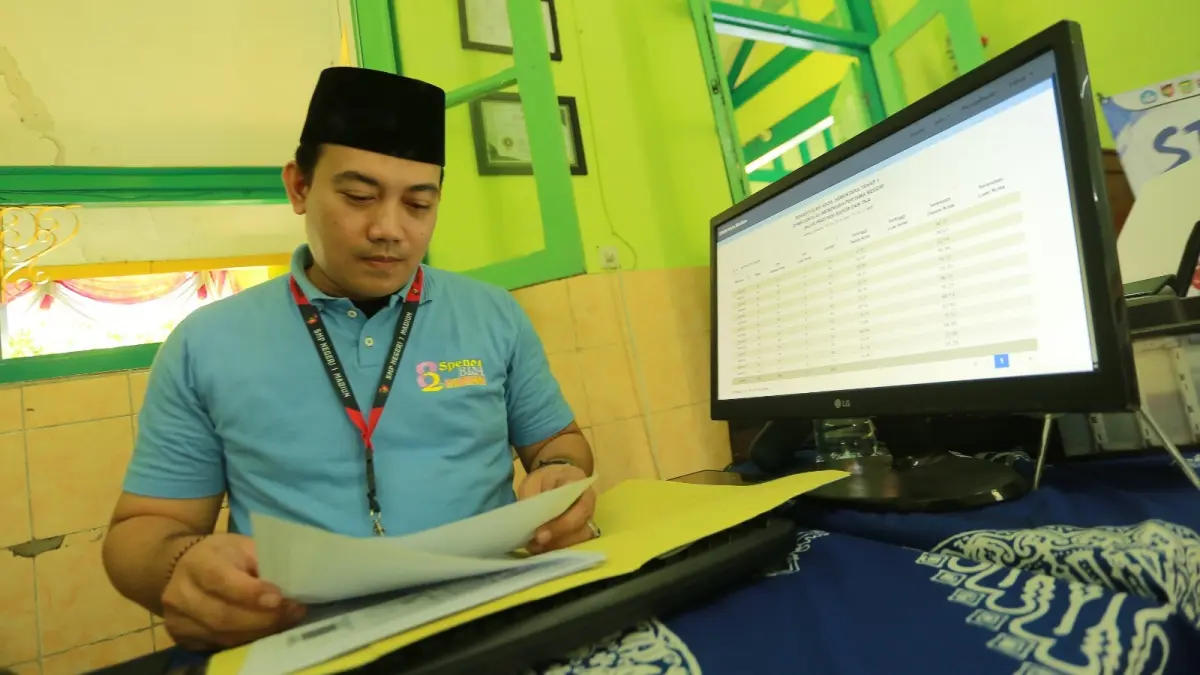 Petugas SMPN 1 Madiun mengecek hasil Seleksi Penerimaan Murid Baru (SPMB) tahap pertama. BAGAS BIMANTARA/RADAR MADIUN