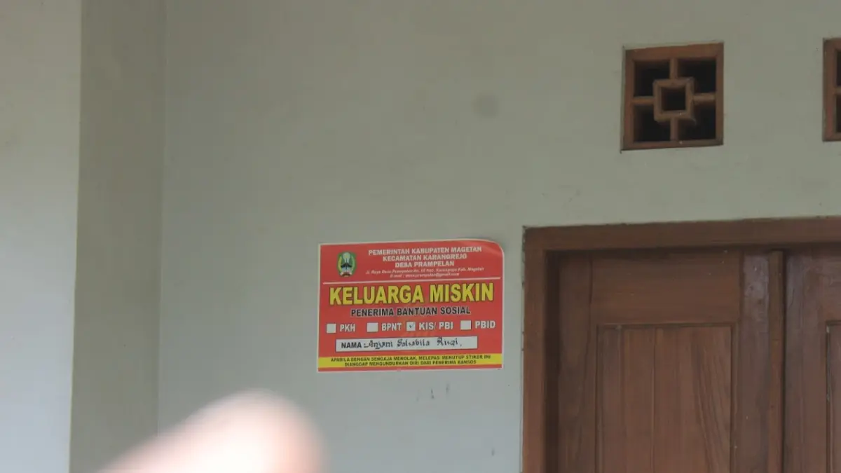 Petugas memasang stiker pada rumah keluarga penerima manfaat bantuan sosial di Kabupaten Magetan. AJI PUTRA/RADAR MAGETAN