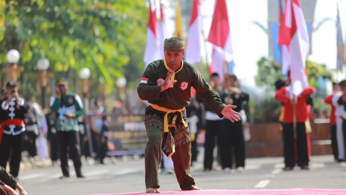 Pendekar dari berbagai perguruan pencak silat menampilkan atraksi budaya dan jurus khas saat mengikuti Kirab Budaya Pencak Silat dalam rangka Hari Jadi ke-108 Kota Madiun, Kamis (25/6). BAGAS BIMANTARA/RADAR MADIUN