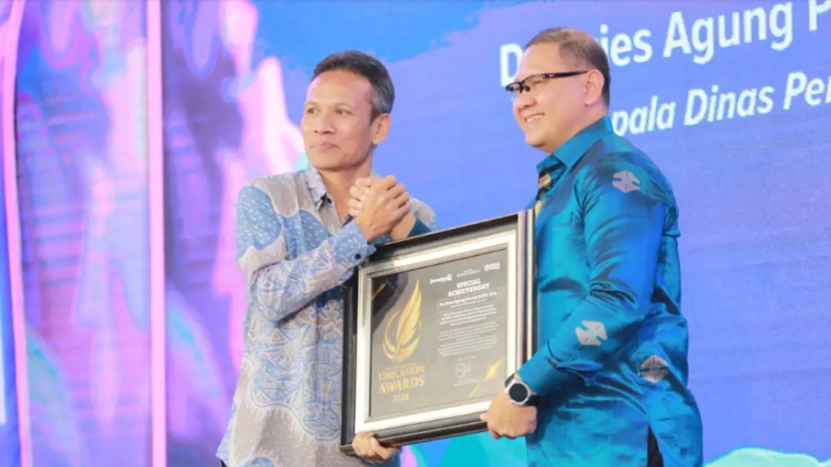 Kadindik Jatim Aries Agung Paewai menerima penghargaan Special Achievement dari Direktur Jawa Pos Radar Marsudi Nurwahid, dalam ajang Radar Madiun Education Awards 2026, Minggu (28/6). (BAGAS BIMANTARA/RADAR MADIUN)