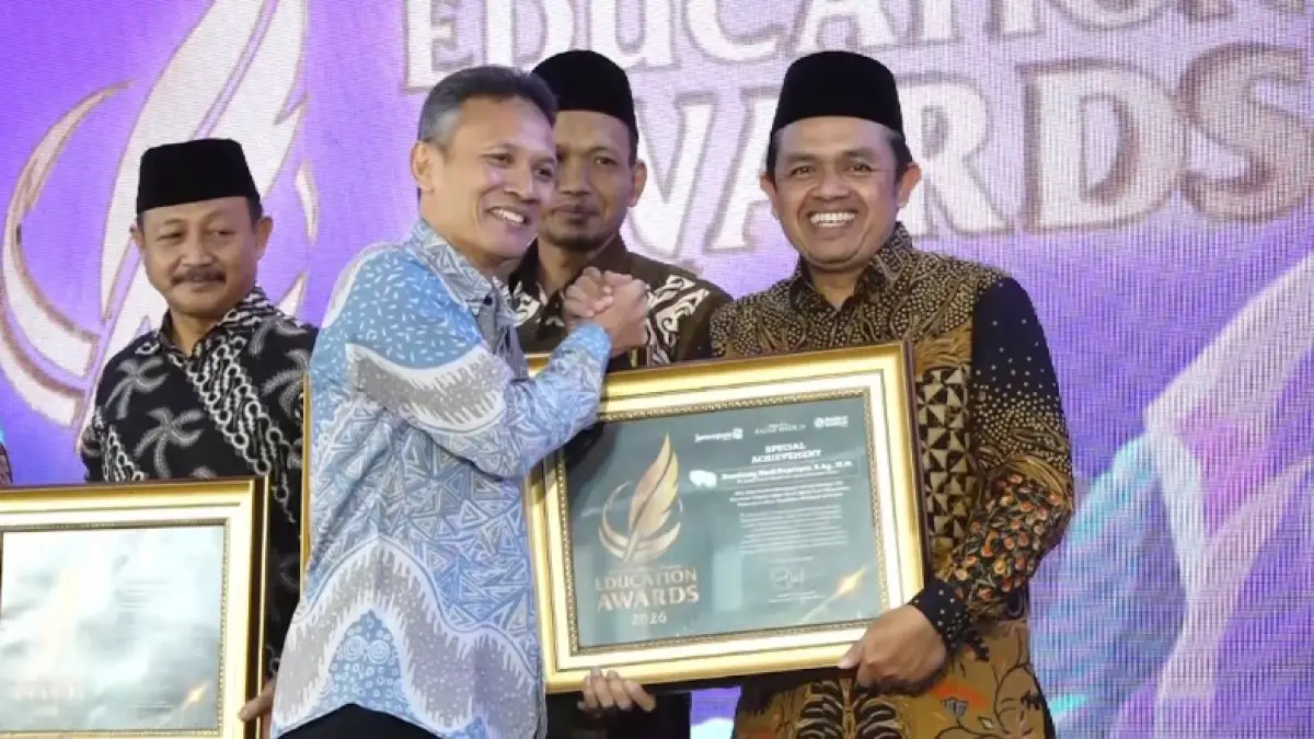 DEDIKASI: Plt Kepala Kantor Kemenag Pacitan Bambang Hadi Suprapto menerima penghargaan Special Achievement dari Direktur Jawa Pos Radar Marsudi Nurwahid. (BAGAS BIMANTARA/RADAR MADIUN)
