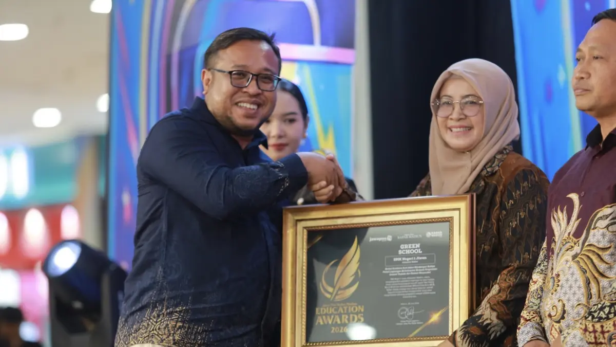 Direktur Jawa Pos Radar Madiun Ockta Prana Lagawira menyerahkan penghargaan Green School kepada Kepala SMKN 1 Jiwan Tri Mei Handayani dalam ajang Radar Madiun Education Awards 2026, Minggu (28/6).