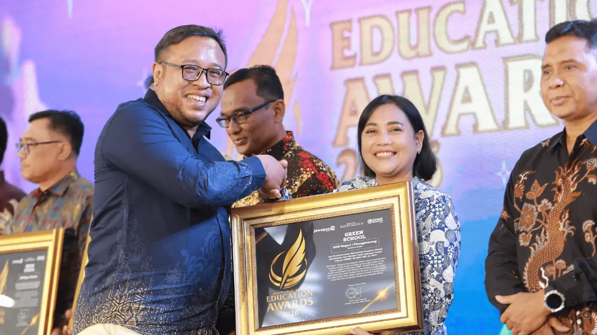 Direktur Jawa Pos Radar Madiun Ockta Prana Lagawira menyerahkan penghargaan Green School kepada Kepala SMPN 1 Pilangkenceng Heny Sulistyo Rini dalam ajang Radar Madiun Education Awards 2026, Minggu (28/6). (BAGAS BIMANTARA/RADAR MADIUN)