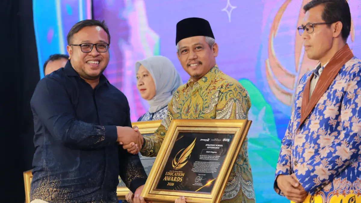 Direktur Jawa Pos Radar Madiun Ockta Prana Lagawira menyerahkan penghargaan Strategic School Governance kepada Kepala MAN 3 Magetan Basuki Prihatin dalam ajang Radar Madiun Education Awards 2026, Minggu (28/6). (BAGAS BIMANTARA/RADAR MADIUN)

