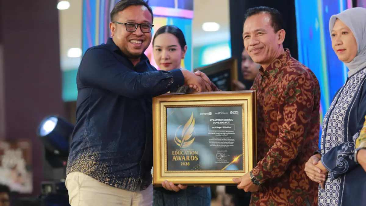 Direktur Jawa Pos Radar Madiun Ockta Prana Lagawira menyerahkan penghargaan Strategic School Government kepada Kepala SMAN 6 Madiun Pramudjo Budiarto dalam ajang Radar Madiun Education Awards 2026, Minggu (28/6). (BAGAS BIMANTARA/RADAR MADIUN)