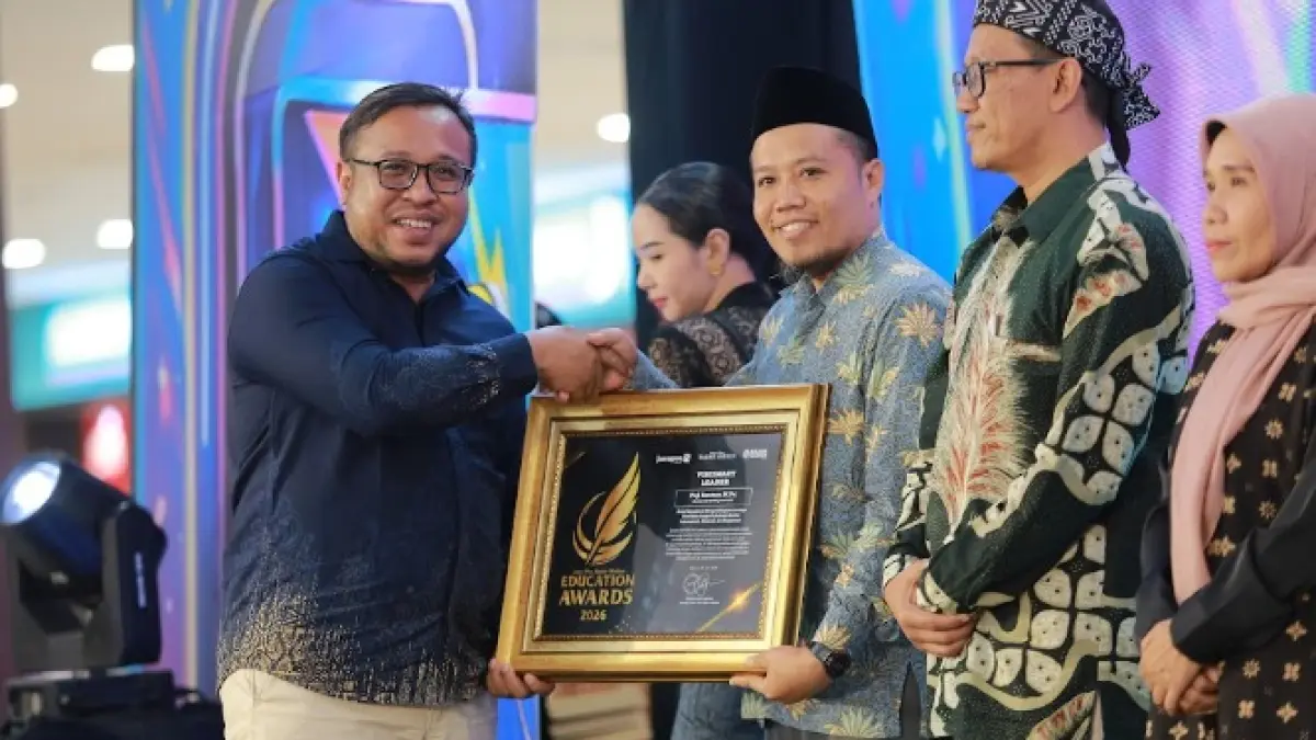 Direktur Jawa Pos Radar Madiun Ockta Prana Lagawira menyerahkan penghargaan Visionary Leader kepada Direktur IIS PSM Puji Santoso dalam ajang Radar Madiun Education Awards 2026, Minggu (28/6). (BAGAS BIMANTARA/RADAR MADIUN)